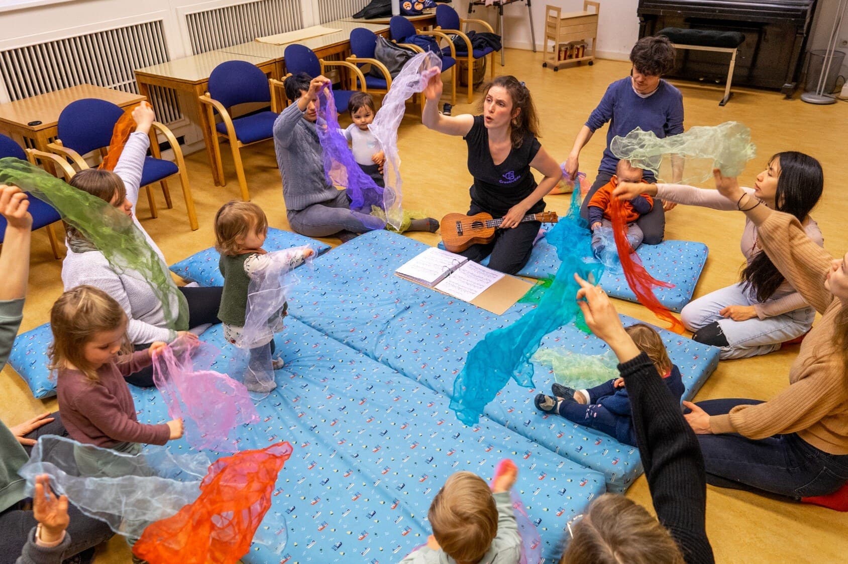 Kita-Gruppe bewegt sich mit bunten Schwungtüchern zur Musik