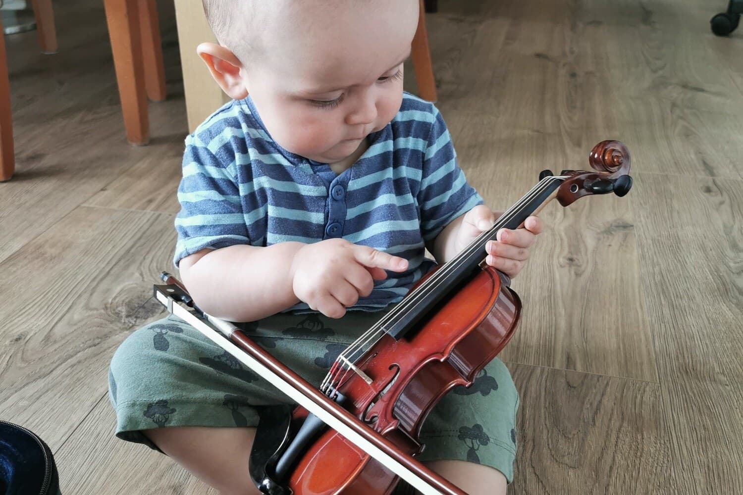Kleines Kind hält konzentriert eine Kindergeige in den Händen